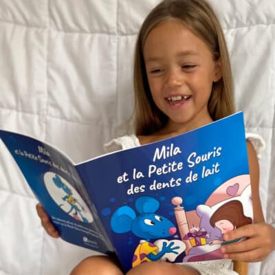 Fillette qui lit un livre personnalisé sur les dents de lait