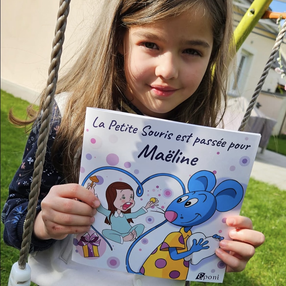 Maëline montre son livre personnalisé