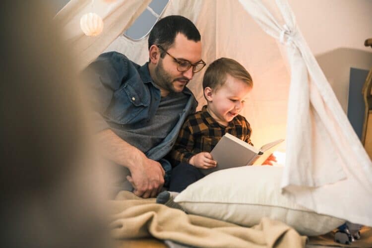 Papa et son garçon en train de lire un livre